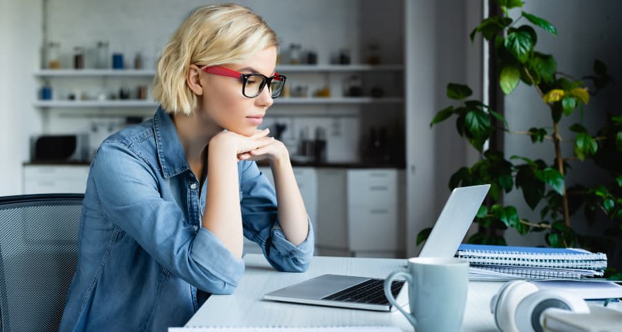 Individual using laptop computer in home workspace